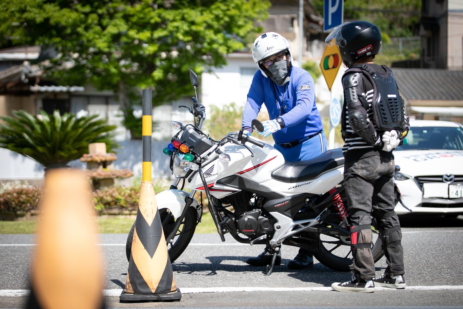 二輪コースで指導員が教習生に説明している