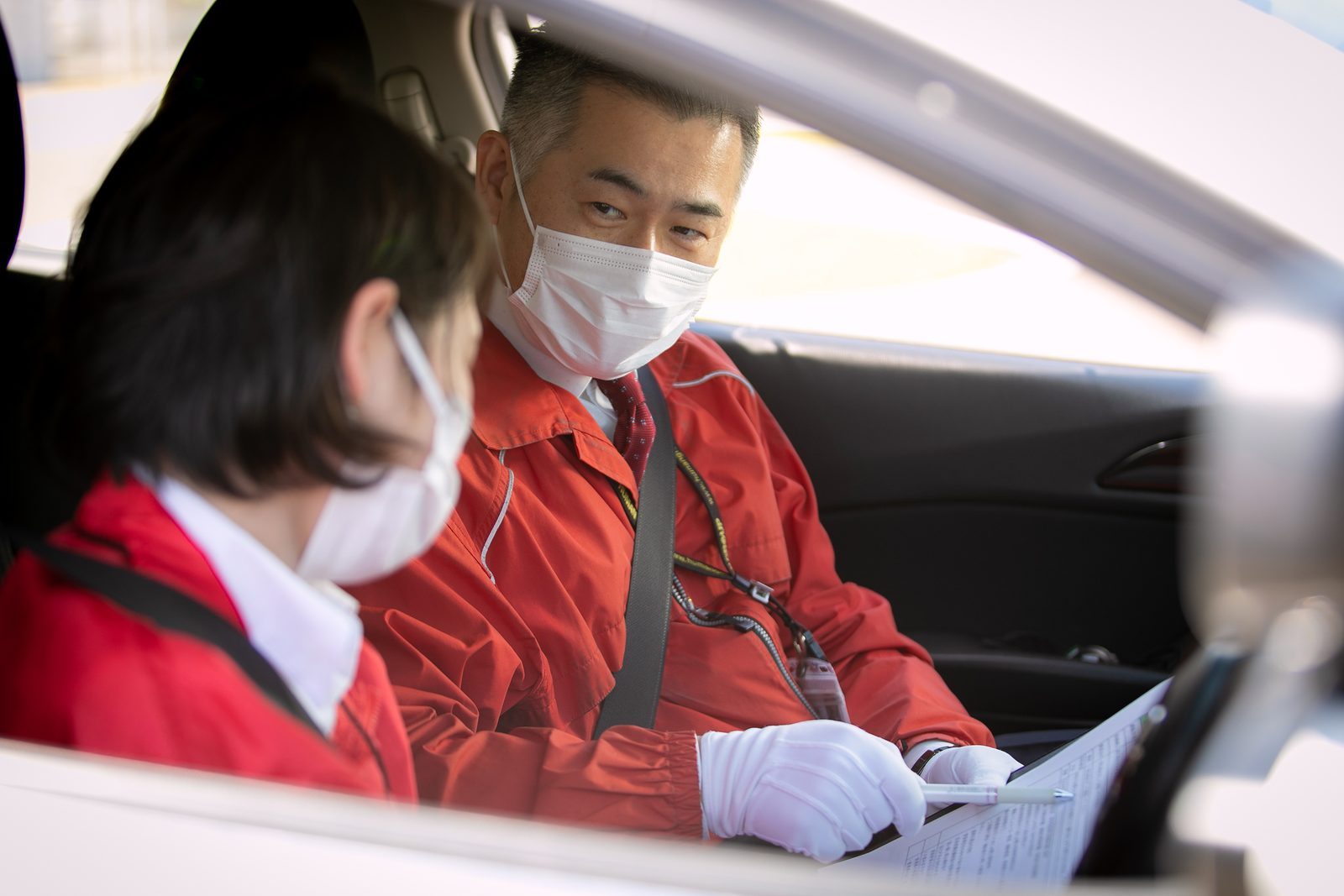 教習車の中で指導員が教習生に説明している